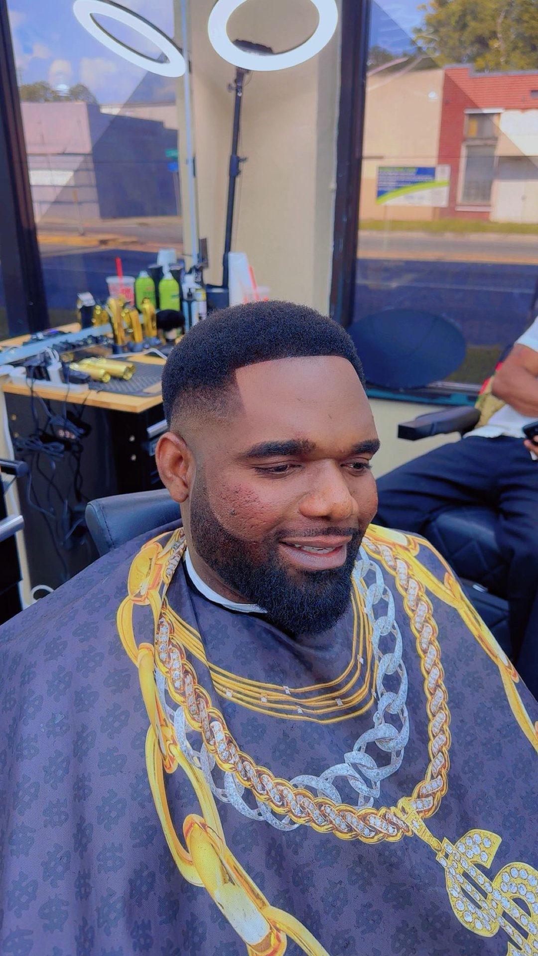 Smiling client with a fresh taper fade and lined-up beard