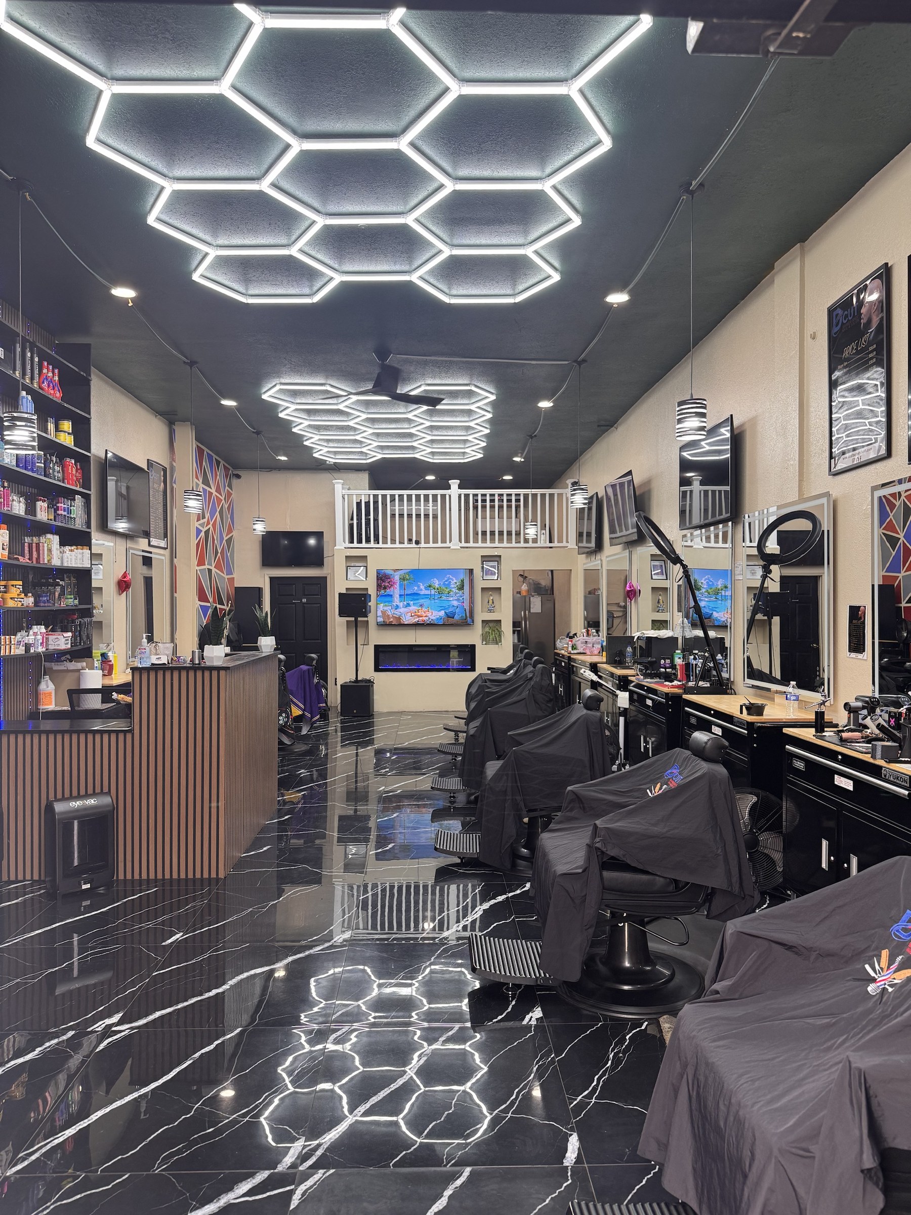 Inside D Cut: hexagon LED ceiling, black marble floor, barber chairs along the right wall